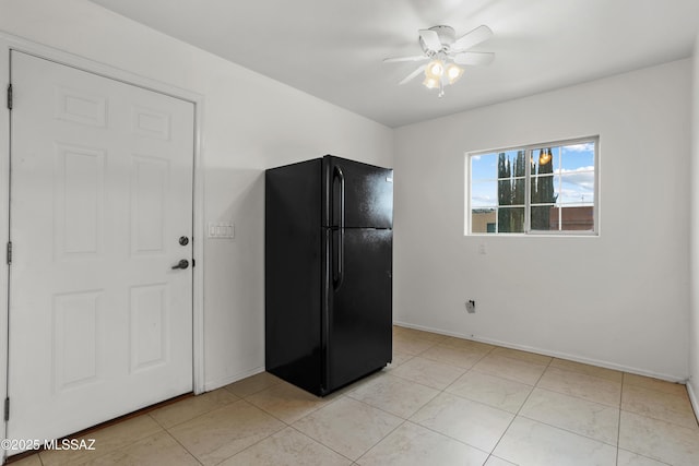 kitchen with black refrigerator, light tile patterned floors, and ceiling fan