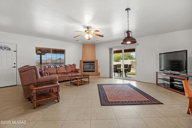 living room featuring light tile patterned floors, a fireplace, and ceiling fan