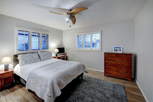 bedroom featuring wood finished floors, a ceiling fan, and baseboards