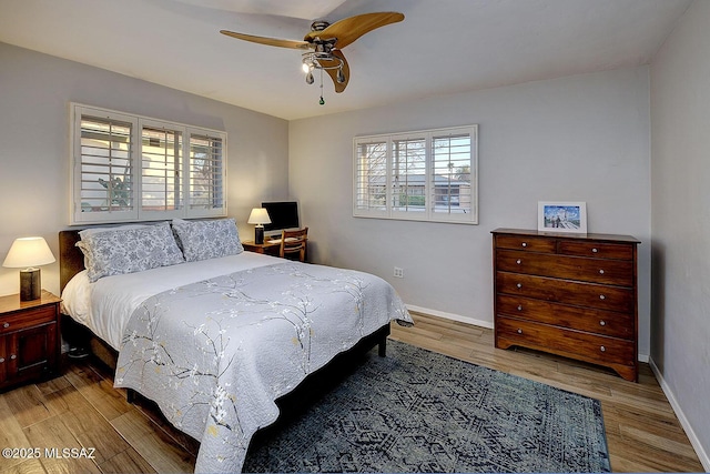 bedroom featuring a ceiling fan, baseboards, and wood finished floors