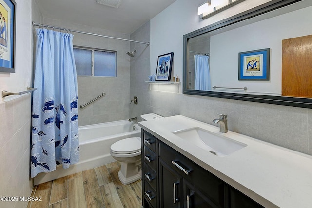 bathroom featuring tile walls, toilet, shower / tub combo, vanity, and wood finished floors