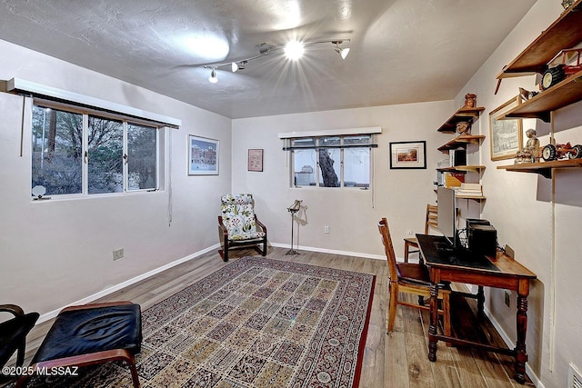 office space with plenty of natural light, baseboards, and wood finished floors