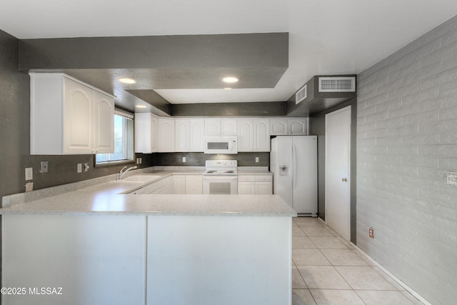 kitchen with sink, white appliances, light tile patterned floors, white cabinets, and kitchen peninsula