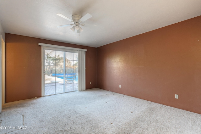 carpeted spare room with ceiling fan