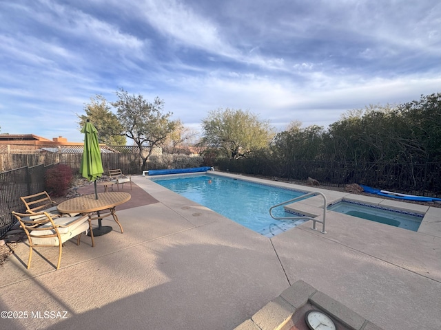 view of swimming pool with a hot tub and a patio