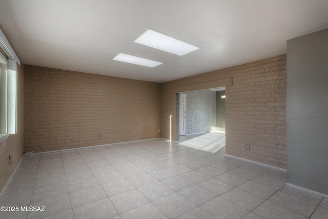 tiled spare room with brick wall