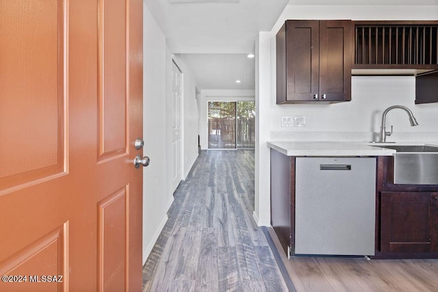 kitchen featuring dark brown cabinetry, dishwasher, sink, and light hardwood / wood-style flooring