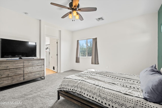 bedroom featuring ceiling fan, ensuite bathroom, and light carpet