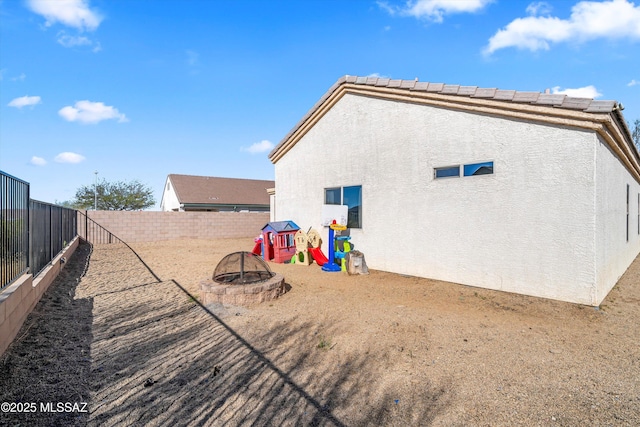 back of property with an outdoor fire pit