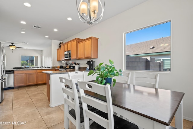 kitchen featuring pendant lighting, a wealth of natural light, kitchen peninsula, and appliances with stainless steel finishes