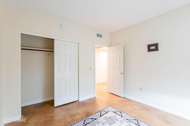 unfurnished bedroom featuring concrete floors and a closet