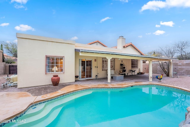 rear view of house featuring a fenced in pool and a patio