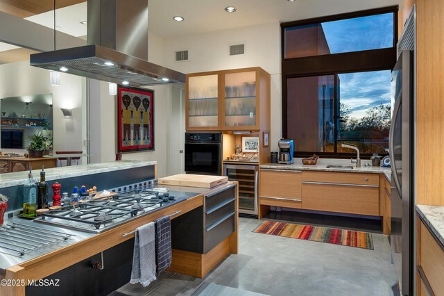 kitchen with wine cooler, visible vents, appliances with stainless steel finishes, glass insert cabinets, and island range hood