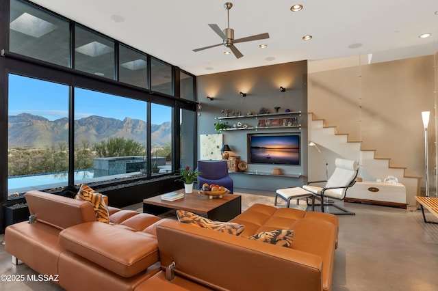 living room featuring concrete floors, expansive windows, stairway, and recessed lighting