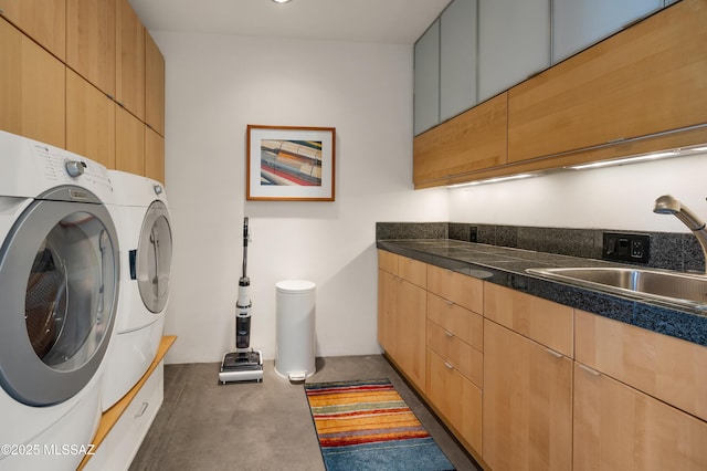 washroom with washer and clothes dryer, a sink, and cabinet space