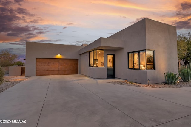 view of front of property featuring a garage, driveway, and stucco siding