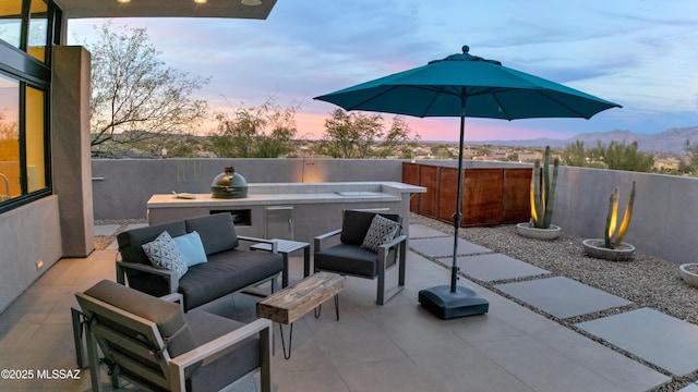 view of patio / terrace featuring a hot tub, fence, and an outdoor hangout area