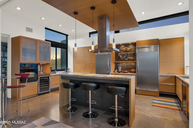 kitchen with wine cooler, appliances with stainless steel finishes, island exhaust hood, a kitchen bar, and pendant lighting