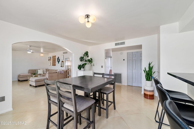 tiled dining space with ceiling fan