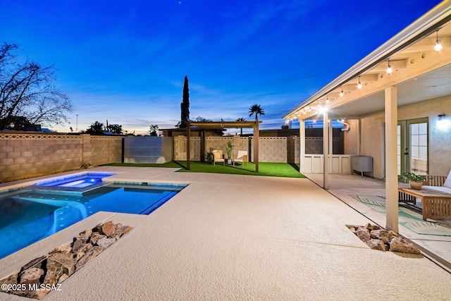 pool at dusk featuring a patio area and an in ground hot tub