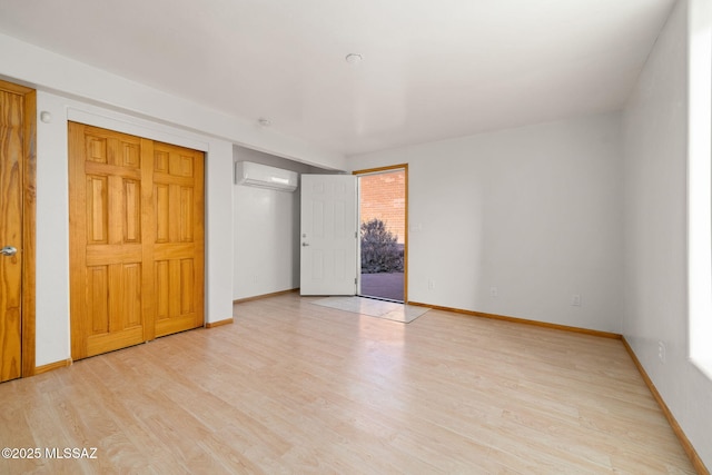 unfurnished bedroom with a wall mounted air conditioner, light hardwood / wood-style flooring, and access to outside