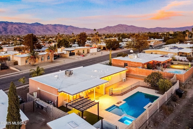 pool at dusk featuring a mountain view