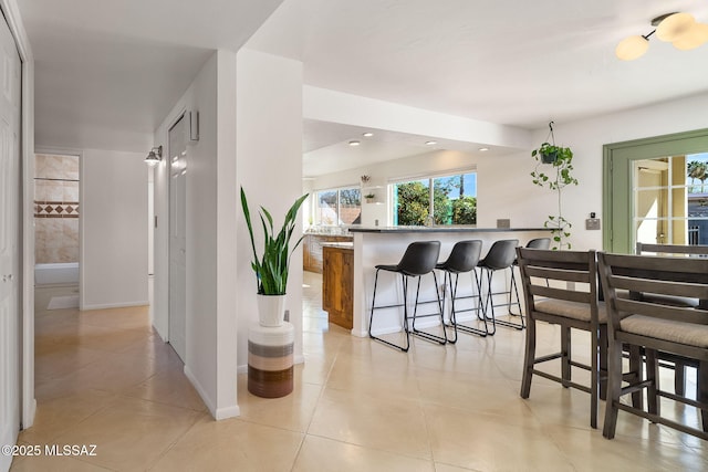 kitchen with a breakfast bar, kitchen peninsula, and light tile patterned floors