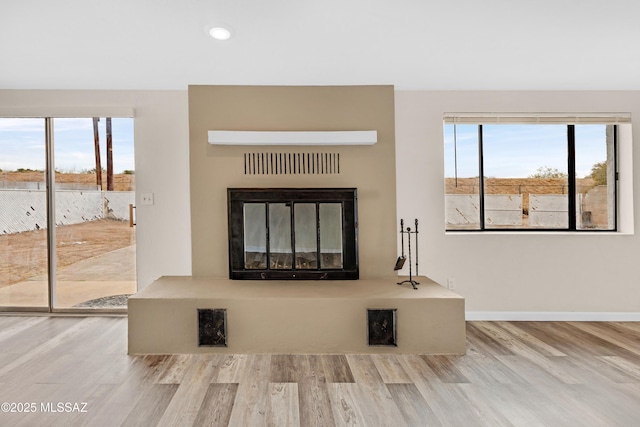 unfurnished living room with a healthy amount of sunlight and light wood-type flooring