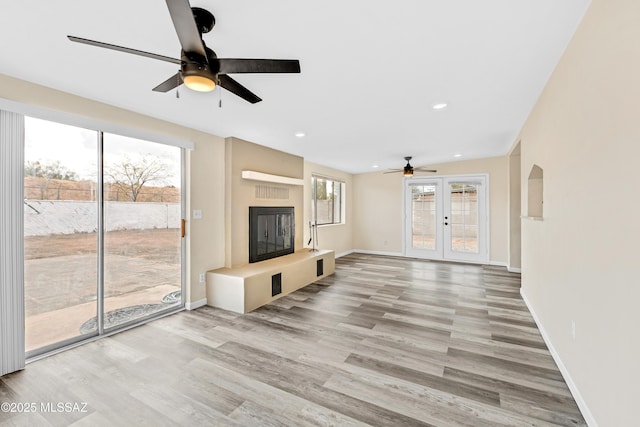 unfurnished living room with wood-type flooring and french doors