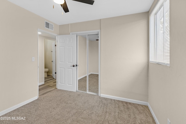 unfurnished bedroom with carpet floors, a closet, and ceiling fan