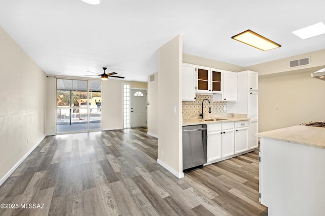 kitchen with tasteful backsplash, dishwasher, sink, and white cabinets