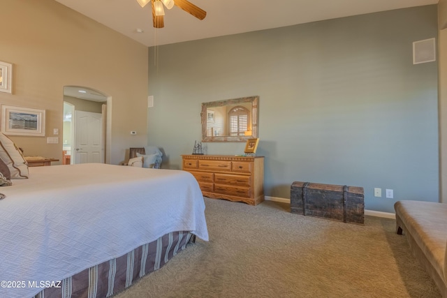 carpeted bedroom with ceiling fan and a high ceiling