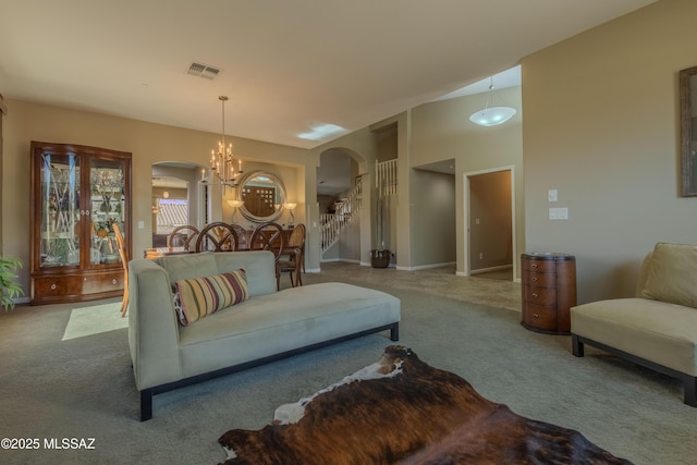 carpeted living room featuring an inviting chandelier