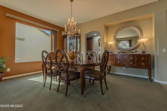 dining space featuring a wealth of natural light, a chandelier, and dark colored carpet