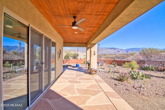 view of patio / terrace with ceiling fan and a mountain view