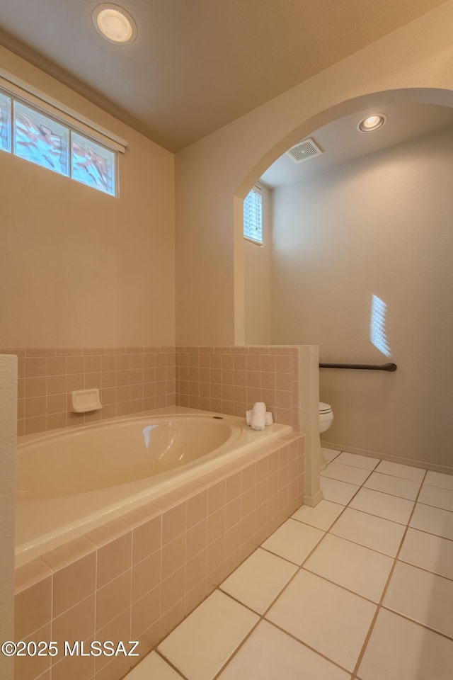 full bath with toilet, visible vents, a bath, and tile patterned floors