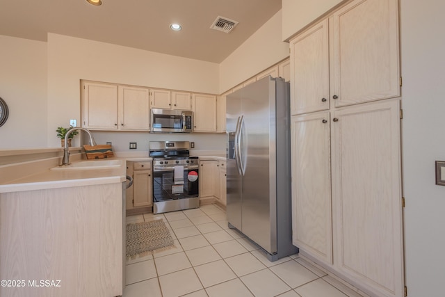 kitchen with light tile patterned flooring, a sink, visible vents, light countertops, and appliances with stainless steel finishes