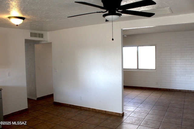 unfurnished room featuring a textured ceiling, tile patterned flooring, visible vents, and a ceiling fan