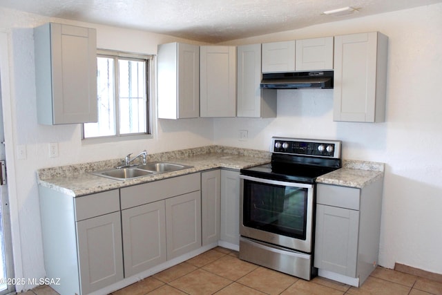 kitchen featuring light countertops, a sink, a textured ceiling, stainless steel range with electric stovetop, and under cabinet range hood