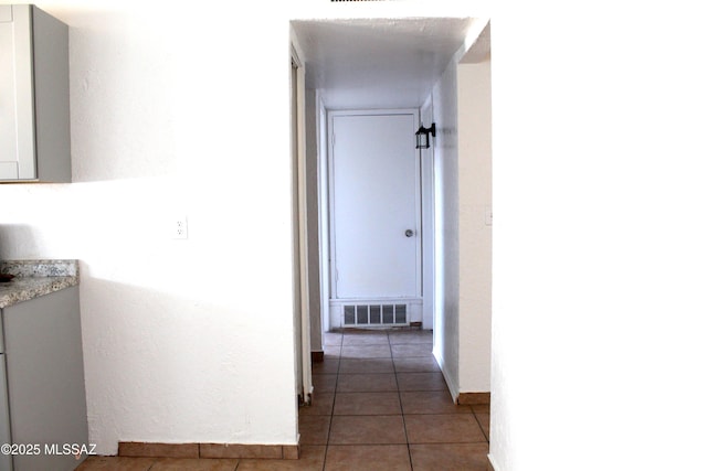 corridor featuring visible vents and tile patterned floors