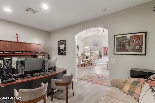 office space with vaulted ceiling and light hardwood / wood-style flooring