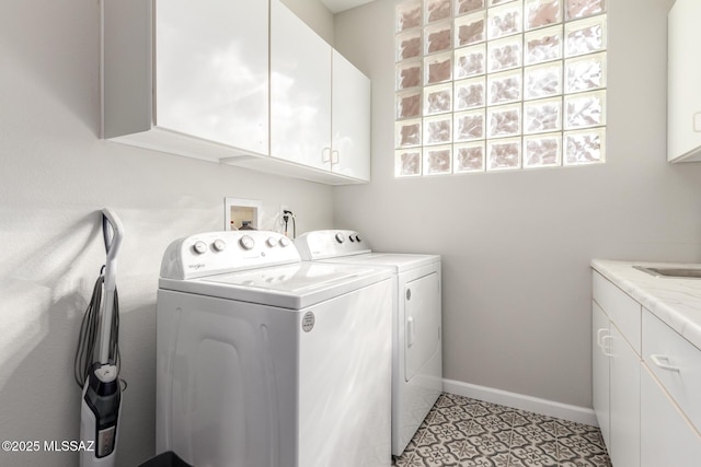 clothes washing area with cabinets and washing machine and clothes dryer