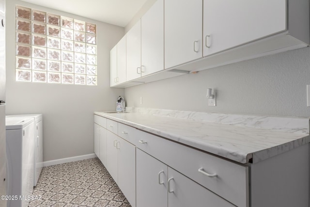 laundry area featuring cabinets, sink, and washing machine and clothes dryer