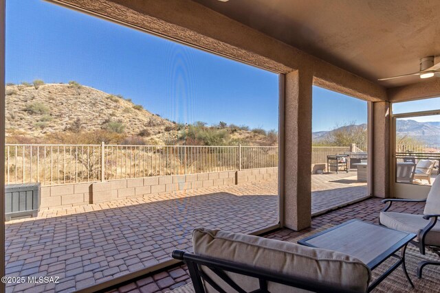 view of patio / terrace featuring ceiling fan and a mountain view