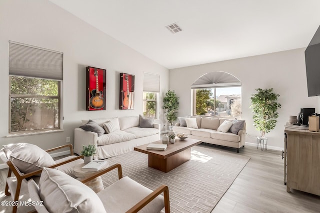 living room with light hardwood / wood-style floors and vaulted ceiling