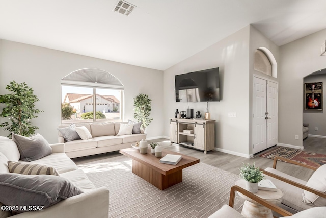 living room featuring lofted ceiling and hardwood / wood-style floors