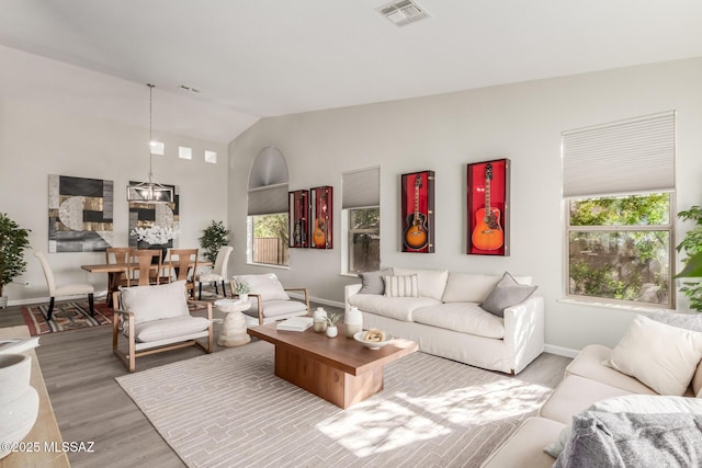 living room with vaulted ceiling, wood-type flooring, and plenty of natural light