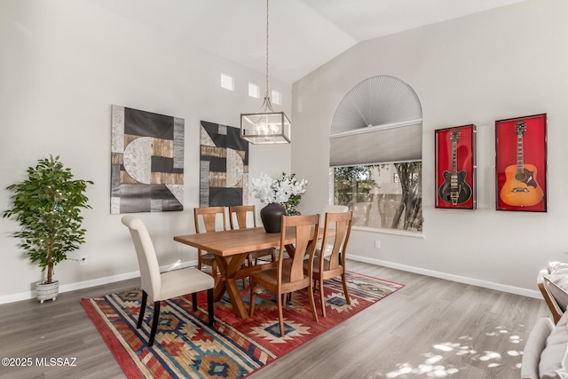 dining room featuring lofted ceiling, hardwood / wood-style floors, and an inviting chandelier