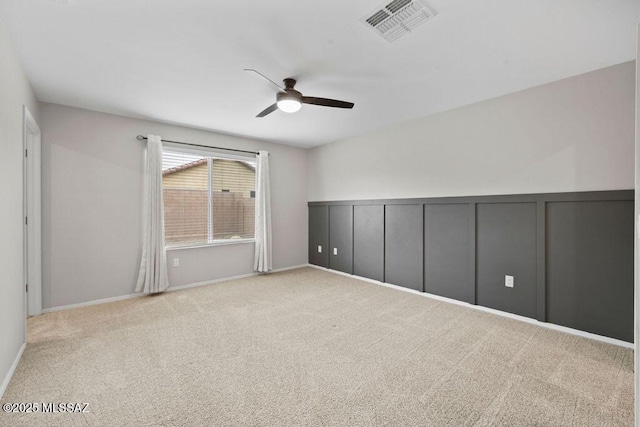 empty room featuring light colored carpet and ceiling fan