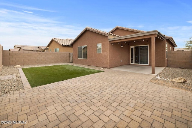 rear view of property with a patio and a lawn